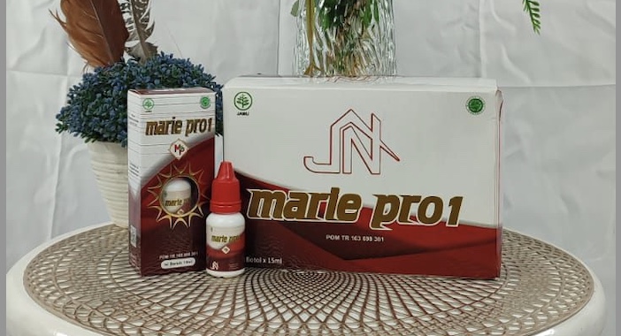 Kemasan Marie Pro1 di atas meja putih bundar dengan latar belakang bunga.